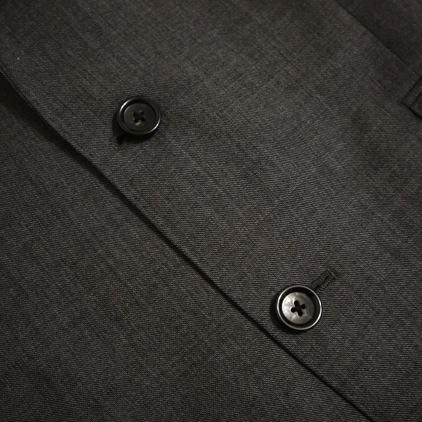 Close-up of a dark gray textured fabric with buttons