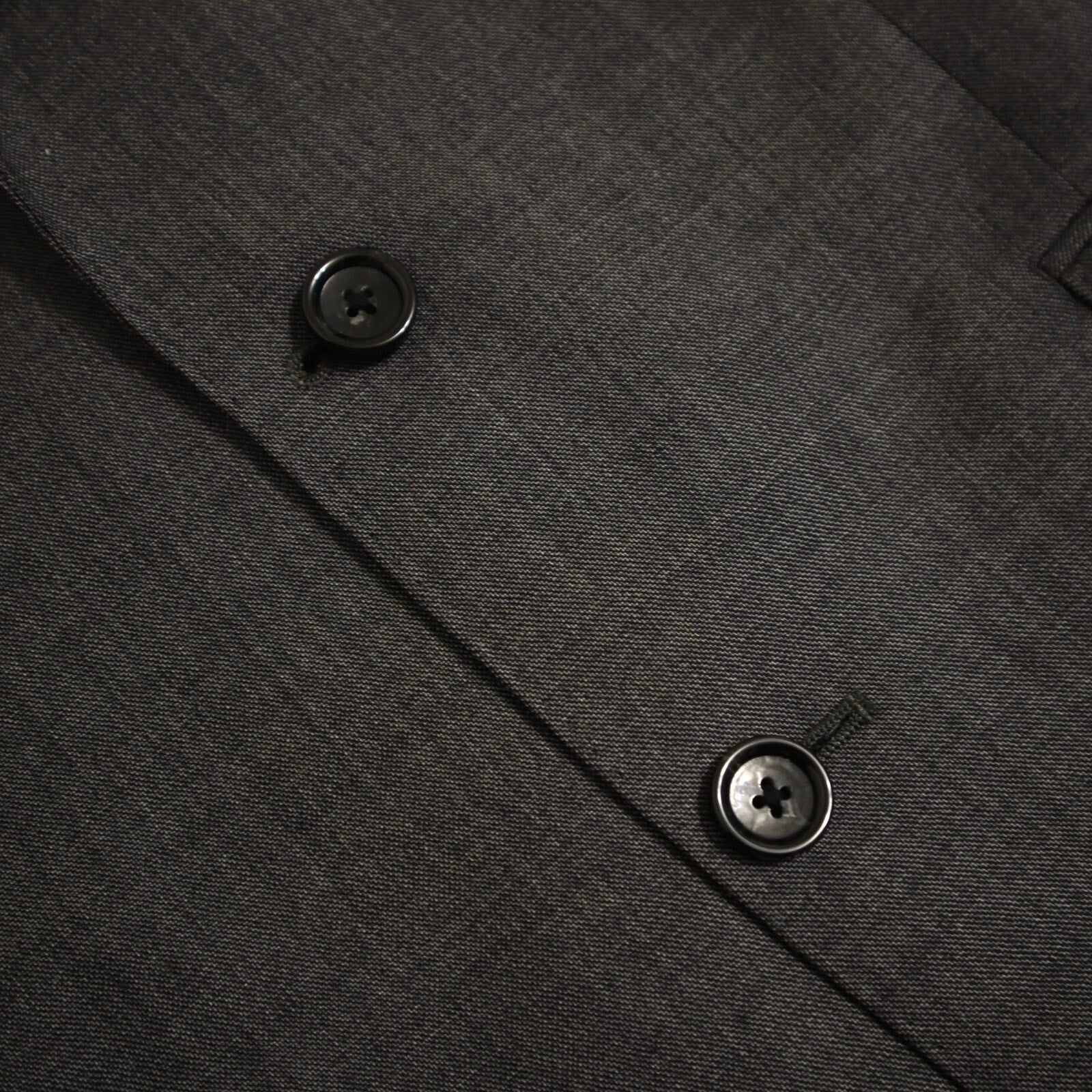 Close-up of a dark gray textured fabric with buttons